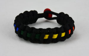 black lgbtq support paracord bracelet with rainbow line and red button in the back