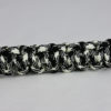 black and white camouflage paracord bracelet across the center of a white background