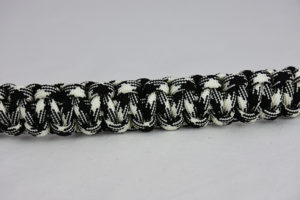 black and white camouflage paracord bracelet across the center of a white background