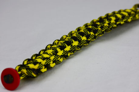black and yellow camouflage paracord bracelet unity band with red button in the corner, picture of a black and yellow camouflage paracord bracelet with red button fastener