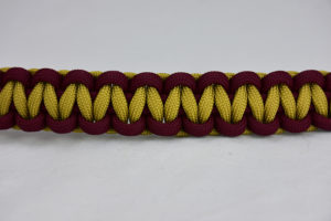 burgundy burgundy and gold paracord bracelet unity band across the center of a white background