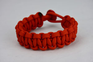 burnt orange paracord bracelet unity band red button back, picture of a burnt orange paracord bracelet unity band with red button fastener in the back on a white background