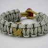 gold and grey pediatric cancer support paracord bracelet unity band, picture of a gold and grey paracord bracelet with a gold ribbon in the center and red button in the back