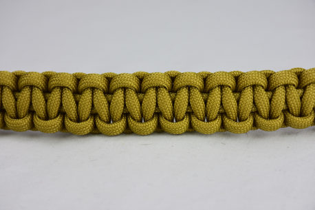 gold paracord bracelet across the center of a white background