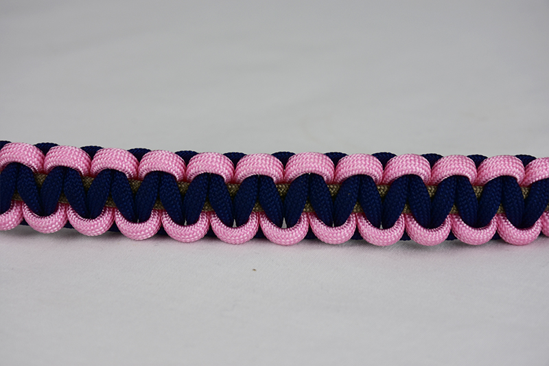 gold soft pink and navy blue paracord bracelet across the center of a white background
