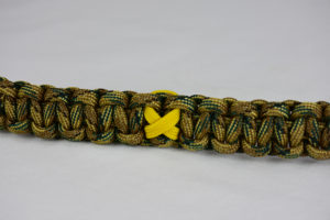 multicam camouflage military support paracord bracelet with yellow ribbon in the center of a white background
