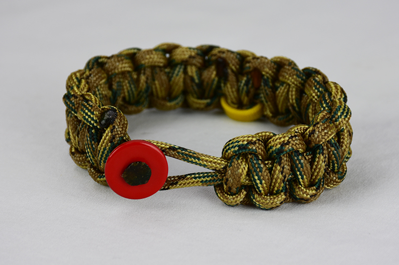 multicam camouflage military support paracord bracelet with red button front, picture of a multicam camouflage military support paracord bracelet with red button and yellow ribbon on a white background