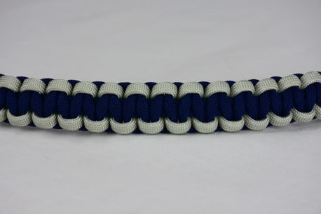 navy blue grey and navy blue paracord bracelet across the center of a white background
