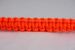 neon orange paracord bracelet across the center of a white background