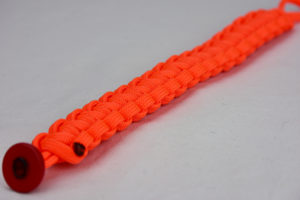 neon orange paracord bracelet unity band with red button, picture of a neon orange paracord bracelet with red button fastener in the corner