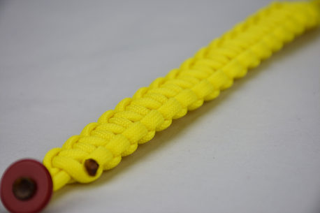 red button neon yellow paracord bracelet going from the bottom corner, neon yellow paracord bracelet unity band with red button