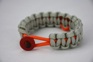 orange and grey leukemia support paracord bracelet with orange ribbon and red button, picture of a orange and grey paracord bracelet unity band with a orange ribbon in the center and red button fastener in the front of the picture, leukemia support