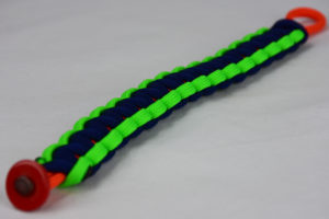 orange neon green and navy blue paracord bracelet unity band with red button in the corner, picture of an orange neon green and navy blue paracord bracelet unity band with red button fastener in the front corner on a white background