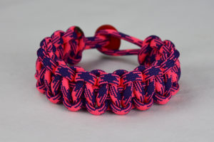 pink and purple camouflage paracord bracelet unity band with red button back, picture of a pink and purple camouflage paracord bracelet with red button fastener in the back on a white background