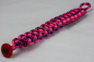 pink and purple camouflage paracord bracelet unity band with red button in the front corner, picture of a pink and purple camouflage paracord bracelet unity band with a red button fastener in the front corner on a white background