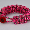 pink camouflage paracord bracelet unity band with red button on front, picture of a pink camouflage paracord bracelet with red button fastener on the front and a white background