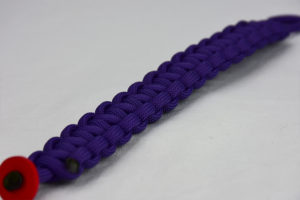 purple paracord bracelet with red button in corner, picture of a purple paracord bracelet with red button fastener in the bottom corner