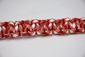 red and white camouflage paracord bracelet unity band across the center of a white background