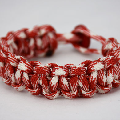 red and white camouflage paracord bracelet with red button in the back, picture of a red and white camouflage paracord bracelet unity band with red button fastener in the back on a white background
