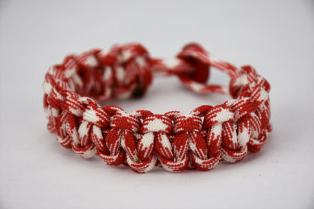 red and white camouflage paracord bracelet with red button in the back, picture of a red and white camouflage paracord bracelet unity band with red button fastener in the back on a white background