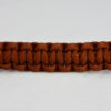 rust paracord bracelet unity band across the center of a white background, rust paracord bracelet unity band