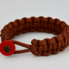rust paracord bracelet with red button in the front, picture of a rust paracord bracelet unity band with red button fastener on a white background