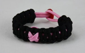 soft pink and black breast cancer support paracord bracelet with red button back and soft pink ribbon