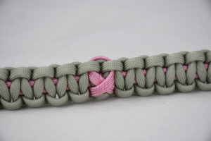 soft pink and grey breast cancer support paracord bracelet with a pink ribbon in the center, picture of a soft pink and grey breast cancer support paracord bracelet unity band with a pink ribbon in the center of the band
