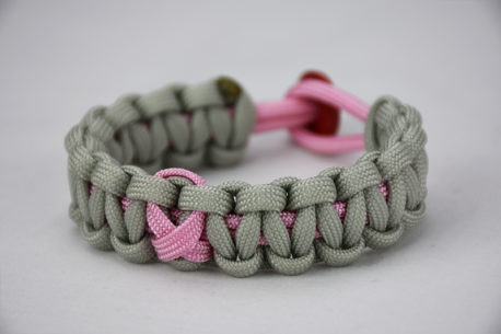 soft pink and grey breast cancer support paracord bracelet with pink ribbon and red button, picture of a unity band soft pink and grey breast cancer support paracord bracelet with a pink ribbon in the center and a red button fastener