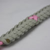 soft pink and grey breast cancer support paracord bracelet, picture of a soft pink and grey breast cancer support paracord bracelet unity band with a pink ribbon in the center and red button fastener in the corner