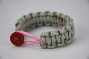 soft pink and grey breast cancer support paracord bracelet with a pink ribbon and red button, picture of a soft pink and grey breast cancer support paracord bracelet unity band with a red button in the front and pink ribbon in the back