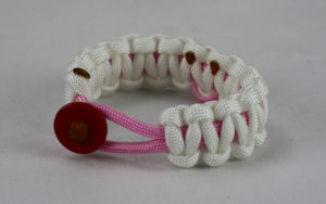 soft pink and white breast cancer support paracord bracelet with red button front and soft pink ribbon