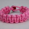 soft pink paracord bracelet unity band with red button, picture of a soft pink paracord bracelet with red button fastener in the back on a white background