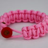 soft pink paracord bracelet unity band with red button in front, picture of a soft pink paracord bracelet unity band with red button fastener in the front on a white background