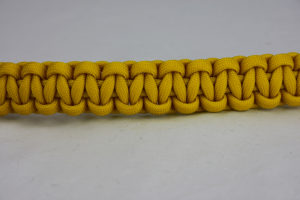 yellow paracord bracelet unity band across the center of a white background