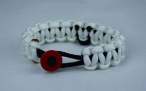black and white pow mia support paracord bracelet with red button in the front and black ribbon