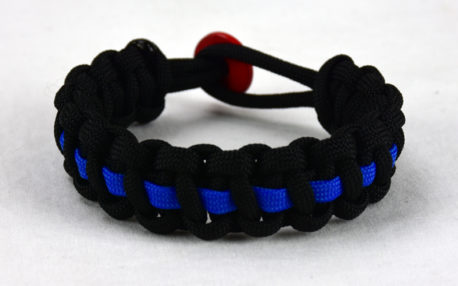 black paracord bracelet with blue line and a red button fastener in the back
