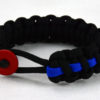 black paracord bracelet with blue line and red button fastener in the front