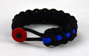 black paracord bracelet with blue line and red button fastener in the front
