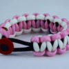 black soft pink and white alzheimers support paracord bracelet with red button in the front and a purple ribbon