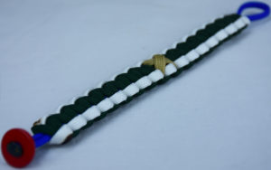 blue white and emerald pediatric cancer support paracord bracelet with red button in the corner and gold ribbon