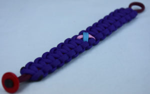 burgundy and purple sids support paracord bracelet with red button in the corner and tarheel blue and pink ribbon