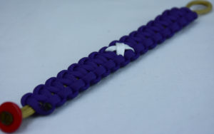 gold and purple multiple sclerosis support paracord bracelet with red button corner and white ribbon