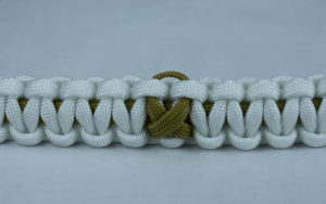 gold and white pediatric cancer support paracord bracelet with gold ribbon in the center