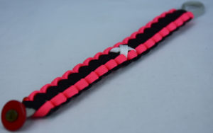 grey pink and black multiple sclerosis support paracord bracelet with red button in the corner and white ribbon