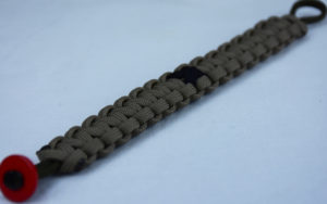 od green and tan pow mia support paracord bracelet with red button in corner and black ribbon