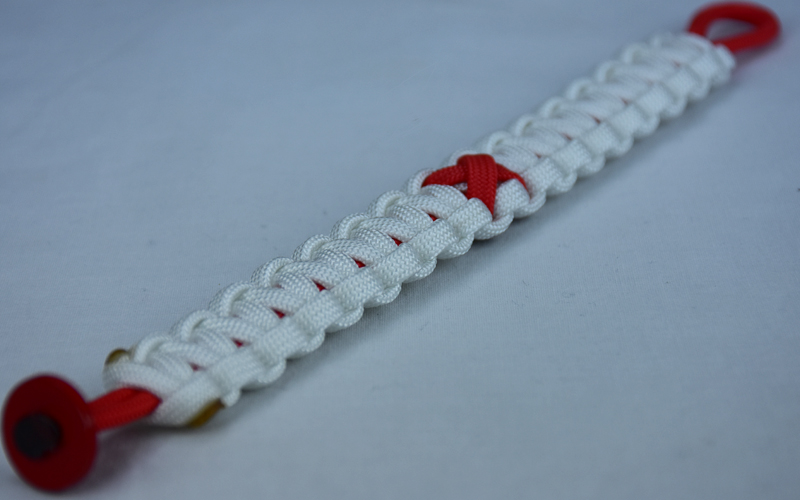 red and white heart disease support paracord bracelet with red button in the bottom corner and red ribbon