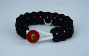 white and black multiple sclerosis support paracord bracelet with red button in the front and white ribbon